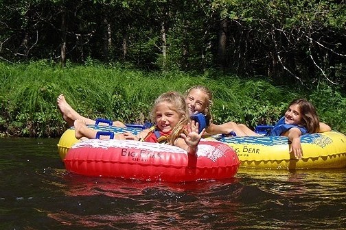 a little girl riding on a raft in the water