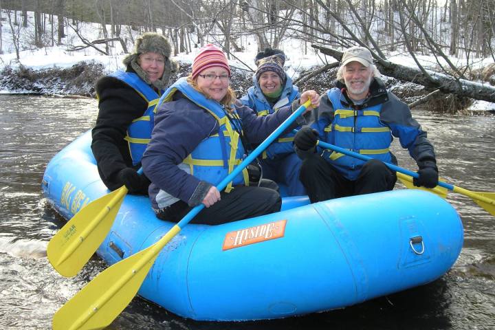 a group of people sitting on a raft in the snow