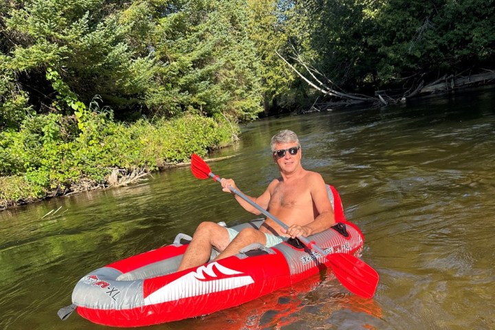 a man riding on the back of a boat in a body of water